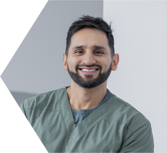 A male nurse smiles at the camera